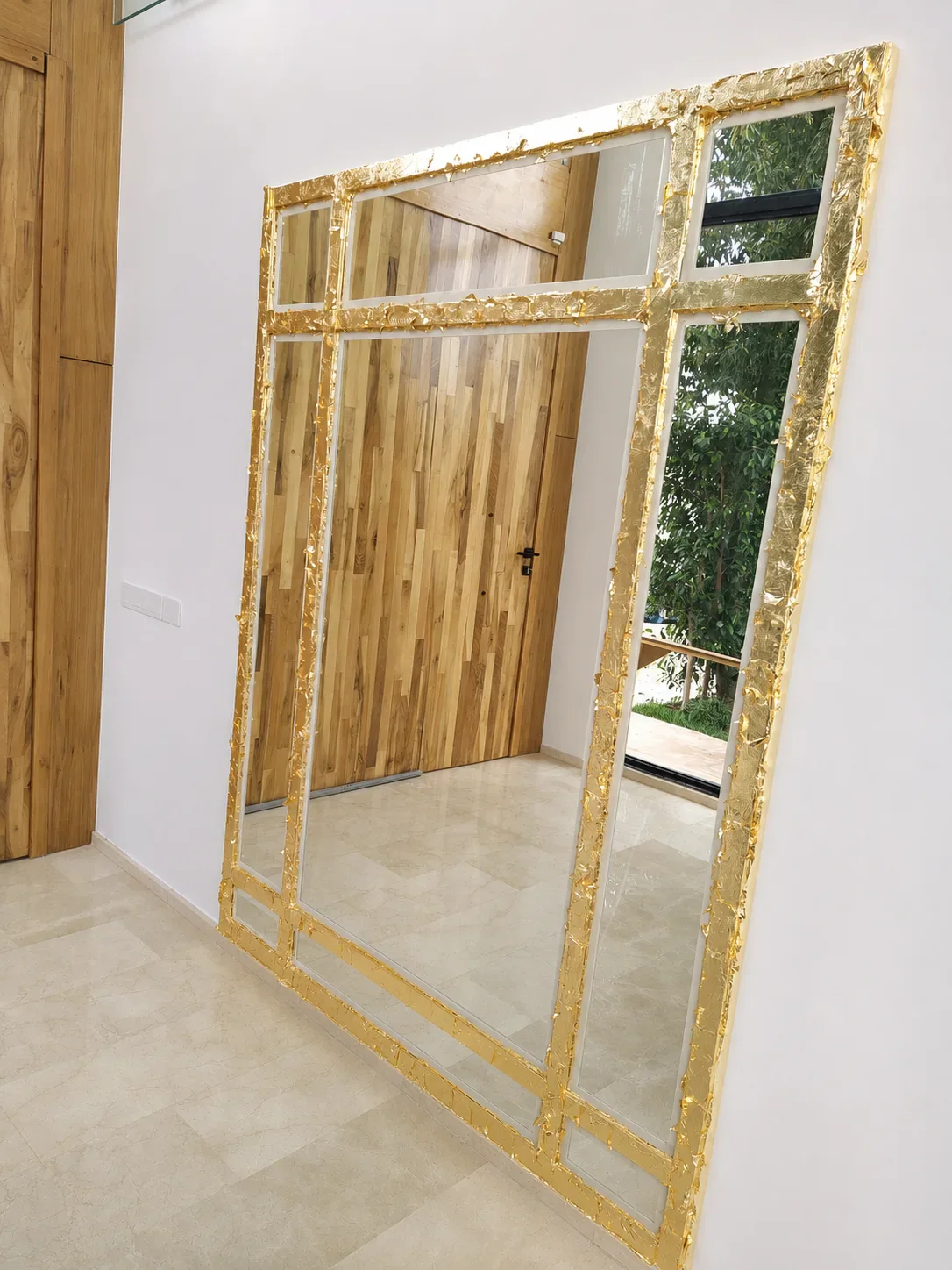 Grand miroir rectangulaire à la feuille d’or dans un intérieur contemporain.